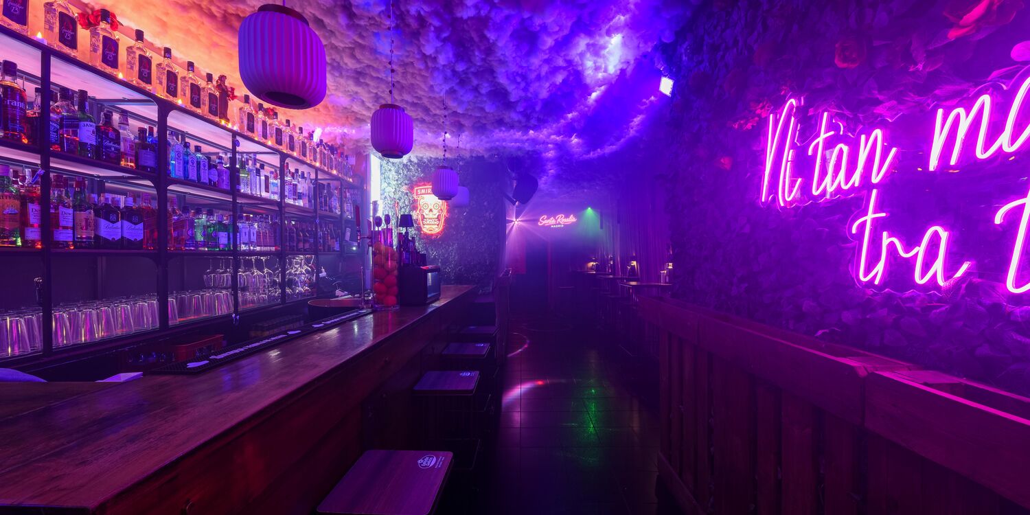 Neón rosa entre niebla morada dentro del bar